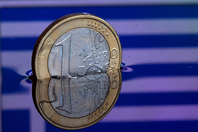 epa04547273 An illustration picture shows a one euro coin in water, which reflects the Greek flag, in Schwerin, Germany, 05 January 2015. The situation in Greece and the monetary policy of the ECB have caused the commom currency euro to drop to its lowest rate since 2006.  EPA/JENS BUETTNER